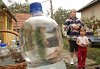 Molnárné Kiss Irén a lajtoskocsiból vett vizet adja a családjának Fotó: Tésik Attila